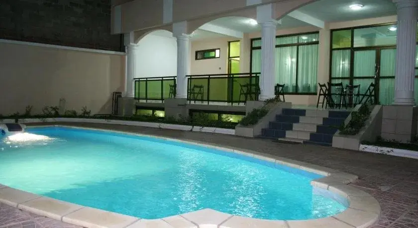 Piscine extérieure et sa terrasse à colonnes